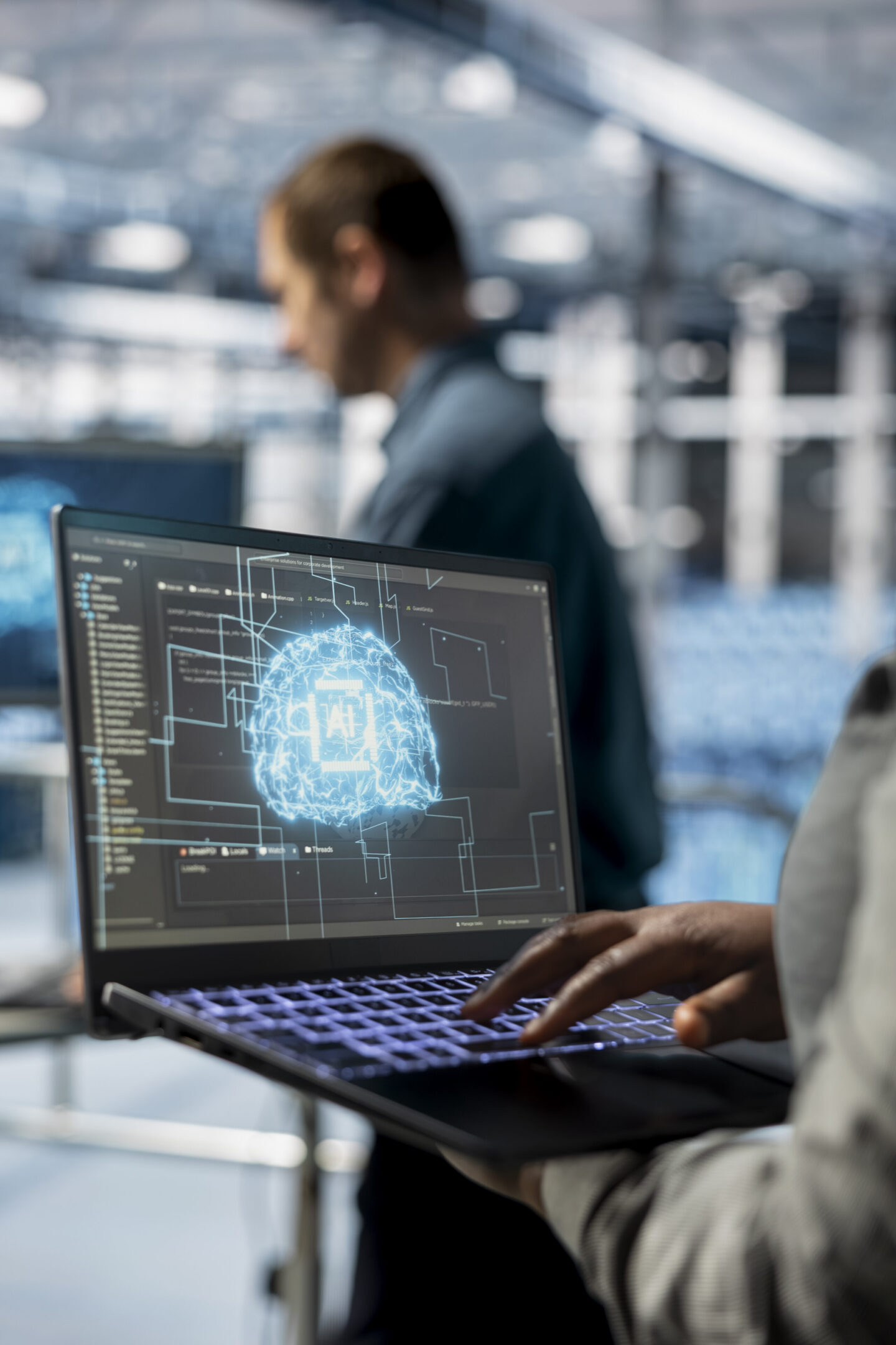 Close up of IT specialist in server hub using laptop to enhance AI model accuracy. Data center engineer using notebook to schedule routine maintenance for AI hardware components